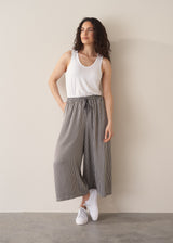 Woman wearing white shirt and stripe wide leg cropped trousers
