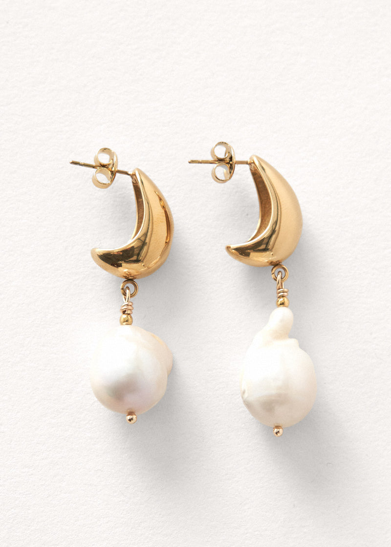 Large pearl drop earrings on white background