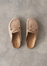Pair of beige moccasin slipper shoes on a grey concrete surface