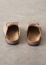 Pair of beige moccasin slipper shoes on a grey concrete surface