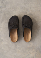 Pair of black moccasin slipper shoes on a grey concrete surface