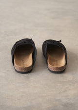 Pair of black moccasin slipper shoes on a grey concrete surface