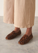 Pair of leopard print loafers on a grey surface