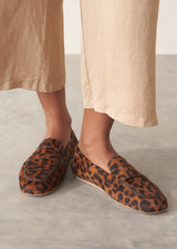 Pair of leopard print loafers on a grey surface