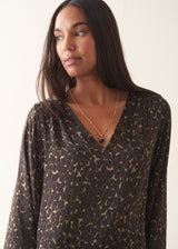 Woman wearing silk blend leopard print blouse and khaki trousers