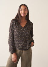 Woman wearing silk blend leopard print blouse and khaki trousers