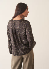 Woman wearing silk blend leopard print blouse and khaki trousers