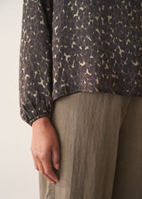 Woman wearing silk blend leopard print blouse and khaki trousers