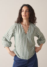 Woman wearing green stripe top with blue jeans