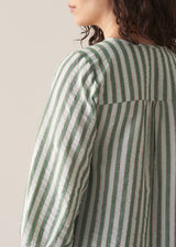 Woman wearing green stripe top with blue jeans