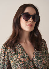 Woman wearing sunglasses with a neutral background