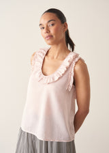 Woman wearing light pink chiffon blouse with ruffle collar and stripe wide leg trousers