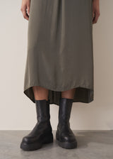 Woman wearing a long dark green satin dress 