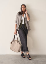 Beige tote bag with brown leather straps on a light beige background