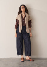 Woman wearing a sheer brown cotton shirt with blue jeans
