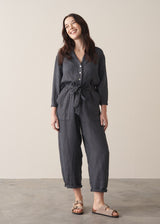 Woman wearing a dark charcoal grey linen jumpsuit 