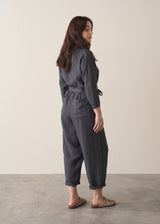Woman wearing a dark charcoal grey linen jumpsuit 